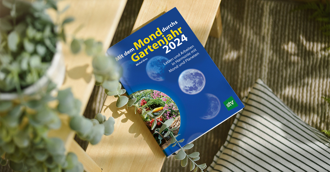 Buch "Mit dem Mond durchs Gartenjahr 2024" vom Stocker Verlag liegt auf einer Gartenbank mit Sukkulente drauf